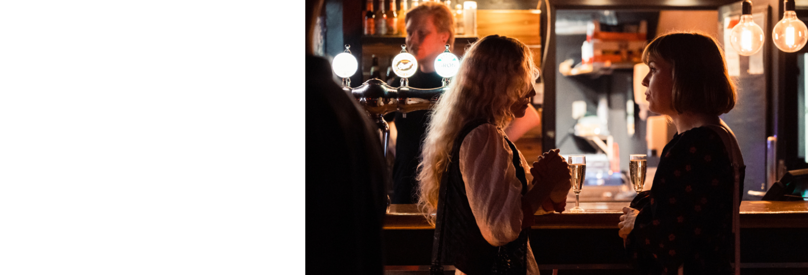 Folk hygger sig i baren i Musikcaféen i dunkelt lys